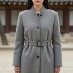 여성 캐시미어 롱자켓의 허리 라인과 소매 디테일 클로즈업