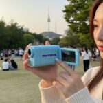 하늘색 멘토스 캠코더를 손에 들고 있는 모습
