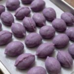 잘 치댄 쑥개떡 반죽이 보라색 면보 위에 놓여 있음