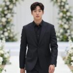 김지원이 네이비 셔츠와 블랙 슬랙스를 입고 결혼식장에 등장한 모습. 미니멀한 실루엣과 실버 시계가 포인트다