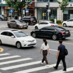 교차로에서 우회전 전 정지선 앞에 완전히 멈춘 차량과 횡단보도를 건너는 보행자