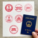 국가유산 여권 스탬프 투어 시작 눈에 띄는 빨간색 국가유산 방문코스 스탬프 거치대와 파란색 방문자 여권을 함께 찍은 사진. 스탬프에는 해당 유산의 상징 문양이 새겨져 있다.
