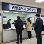 종합소득세 신고를 위해 세무서 입구에서 번호표를 받고 대기 중인 모습. 대기실에는 여러 창구가 안내되어 있다.