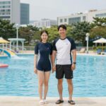 루즈핏 커플 래쉬가드를 입은 부부가 워터파크에서 포즈를 취한 모습
