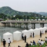 강릉단오제 남대천 행사장 전경, 다리와 강변에 설치된 축제 부스와 관광객들