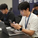 조승원 기자가 IT 컨퍼런스에서 취재하는 동안 스마트폰과 노트북을 활용해 현장 정보를 기록하고 있다.