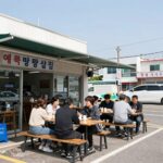 양양 애견동반 식당 기사문밥집과 스누피자 양양 애견동반 식당 기사문밥집의 야외 테이블 모습. 지붕이 있어 비를 피할 수 있고 도로변에 자리잡고 있다.