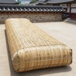 대나무 죽부인 시원하지만 베개로는 아쉬운 점 대나무 죽부인과 대나무 베개를 나란히 놓고 비교한 사진으로, 죽부인은 긴 원통형, 베개는 C자 커브 디자인